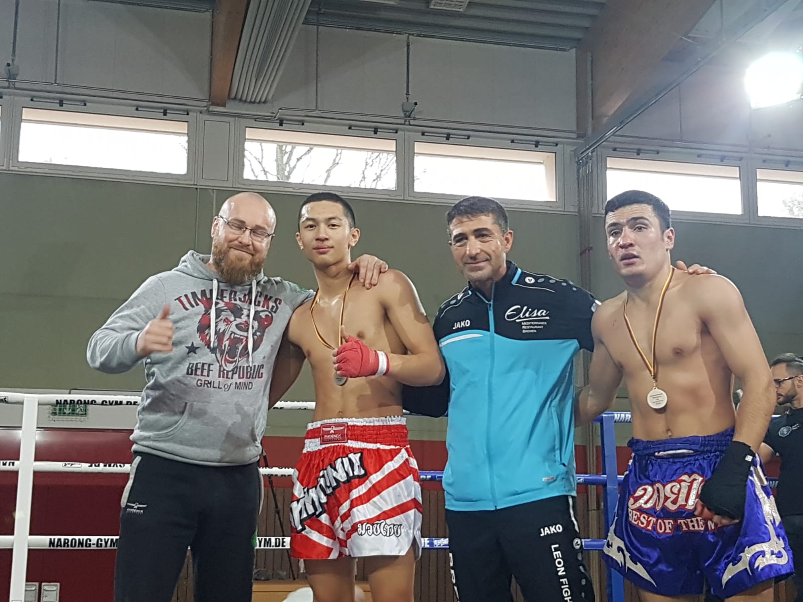 Boxer mit Trainern nach einem Wettkampf im Ring