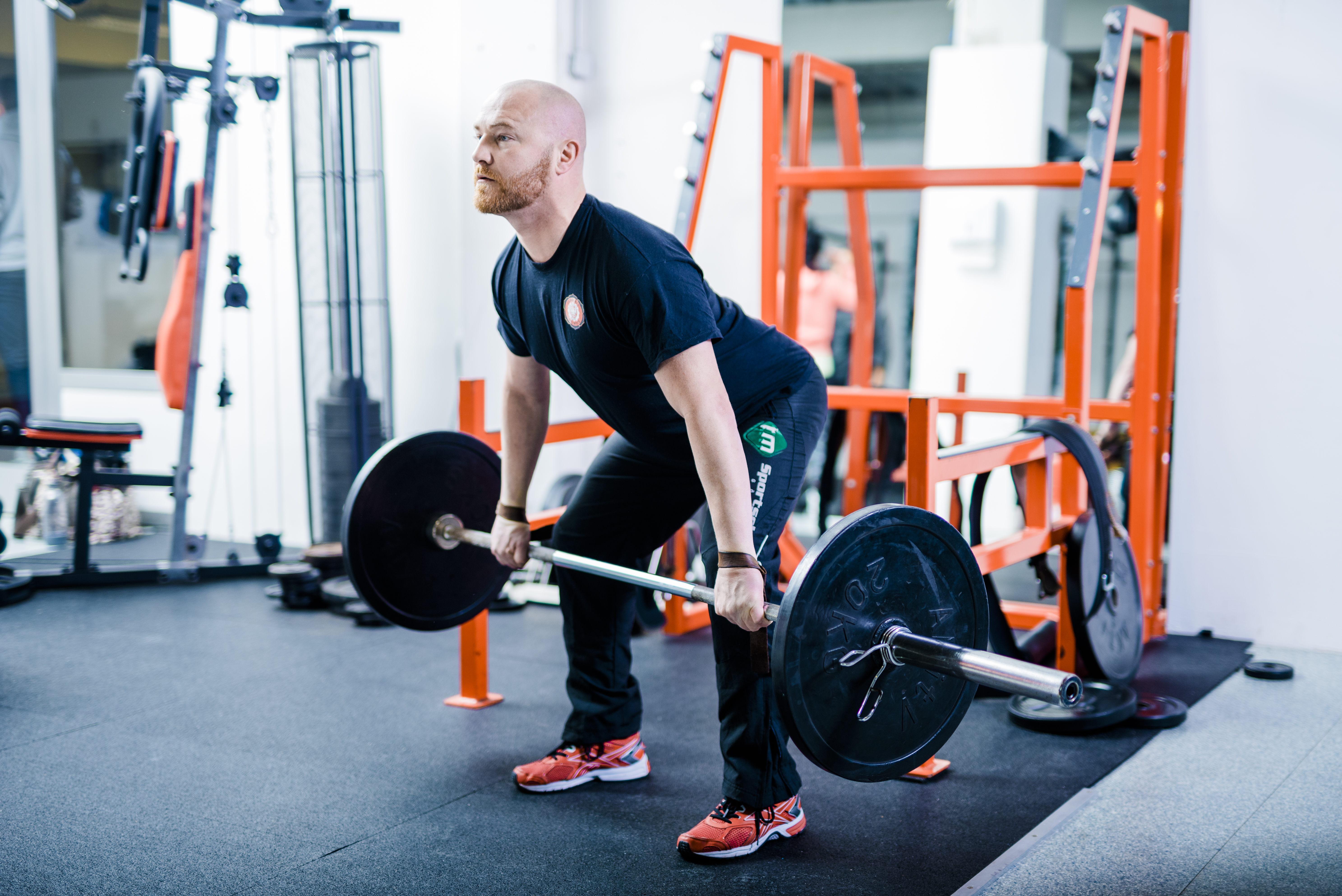 Mann beim Kreuzheben mit der Langhantel im Fitnessraum