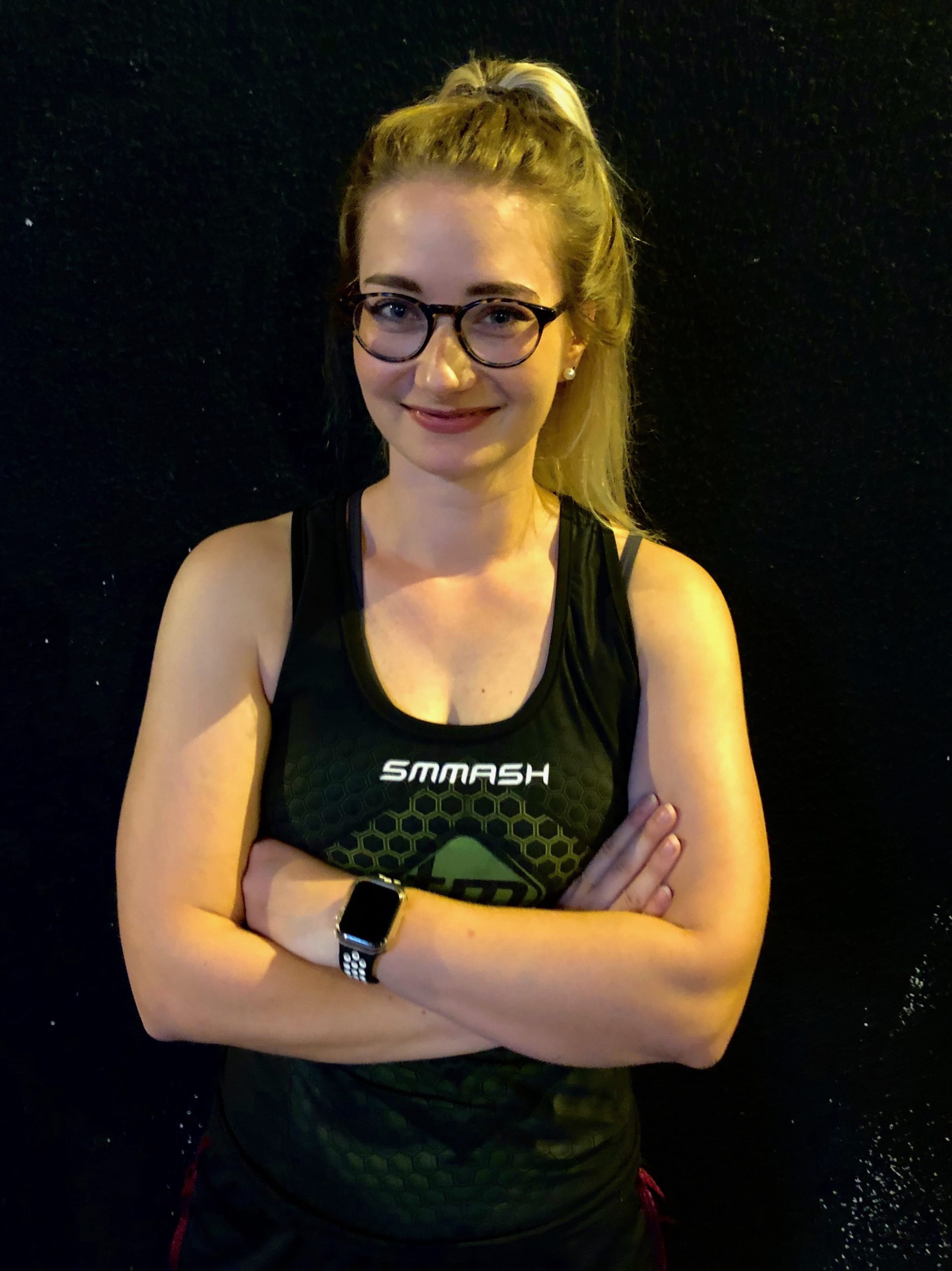 Trainerin in Trainingskleidung mit verschränkten Armen